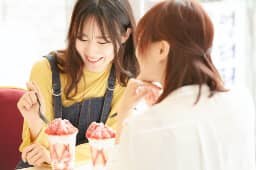 アイスクリームを食べながら話してる二人の女性